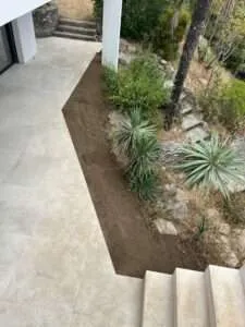 Massif planté et terre végétale le long d'une allée à Coti-Chiavari