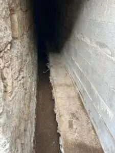 Tranchée étroite de drainage entre deux murs à Tavera