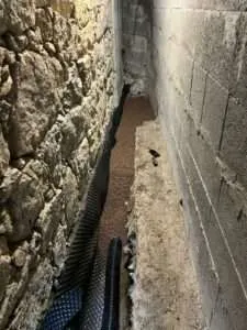Drain et gravier posés le long d'un mur à Tavera