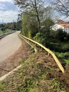 Glissière de sécurité en bois reposée le long d'une route à Afa