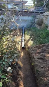 Canalisation d'eaux pluviales posée dans une tranchée de jardin à la Castagna