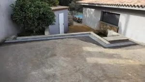 Cour béton et caniveau à grille d'une villa à la Castagna
