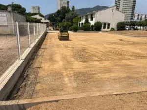 Compacteur à cylindre sur la plateforme du parking le long de la clôture
