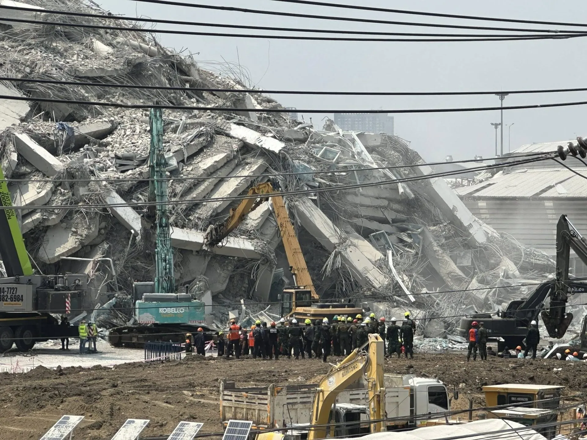 Rescue teams in the collapsed building, revealing the immense challenge ahead.