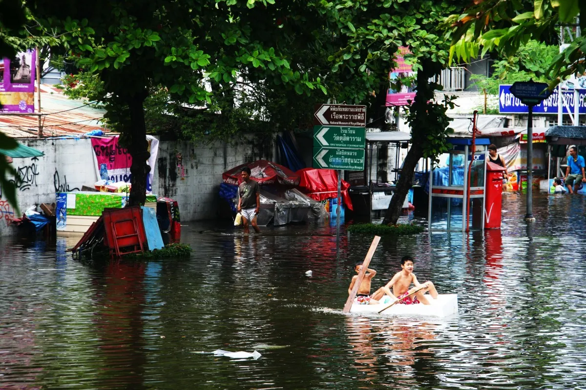 Two boys canoeing during Thai floods