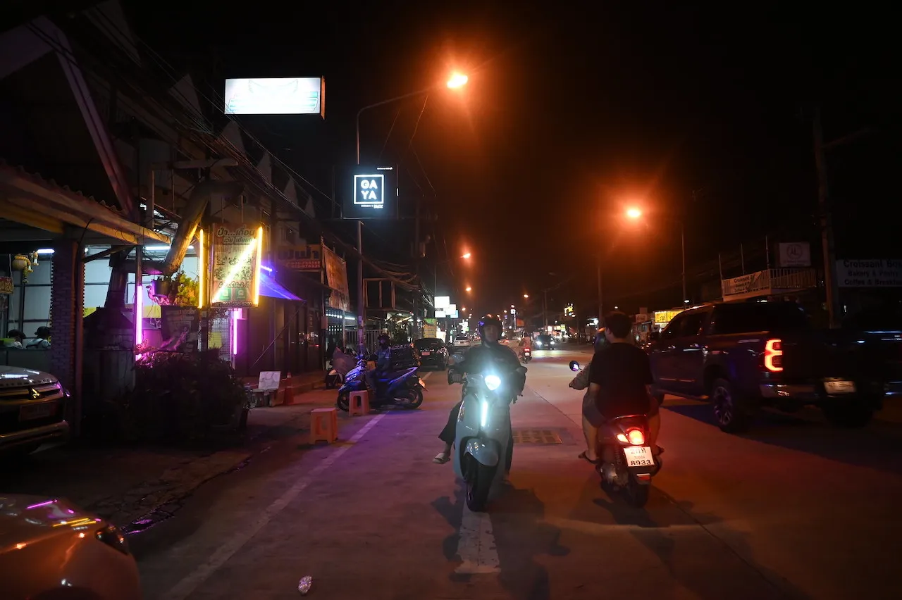 Men riding motorcycles at night on a street in Pattaya.