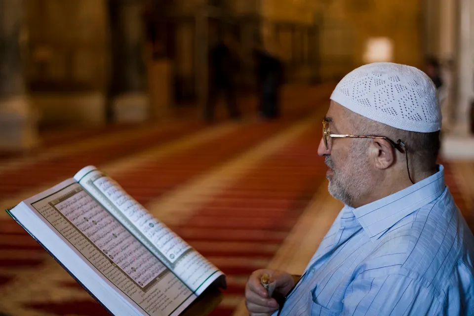 Muslim man reading the Quran in a mosqu