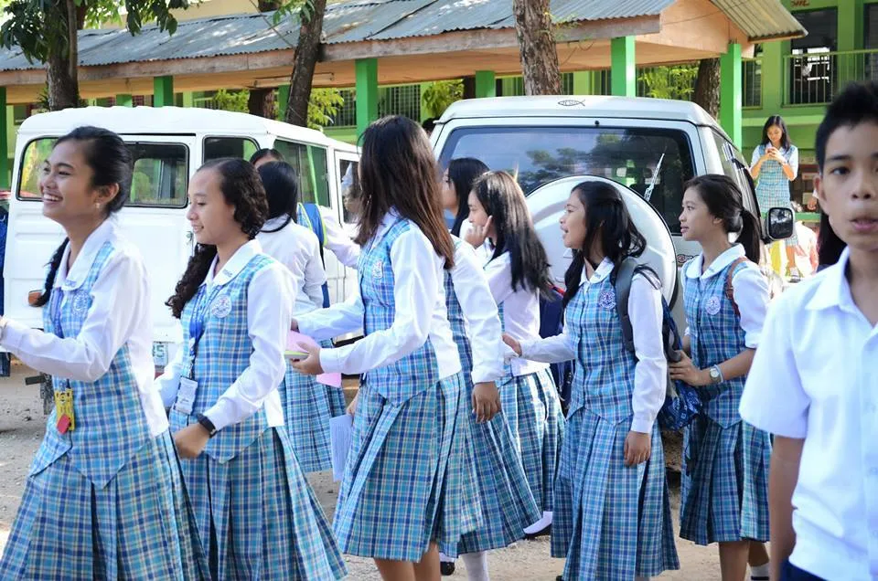Filipino students wearing light blue and white uniforms