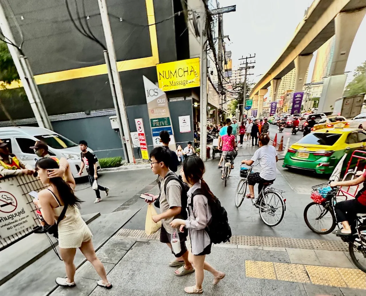 Thai people and passersby walking on Charoen Nakhon Street in Bangkok.