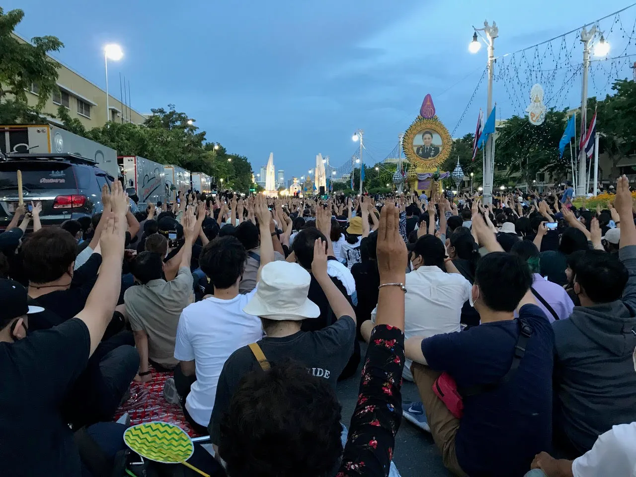 Protesters displaying three-finger salute in front of Democracy Monument in Bangkok