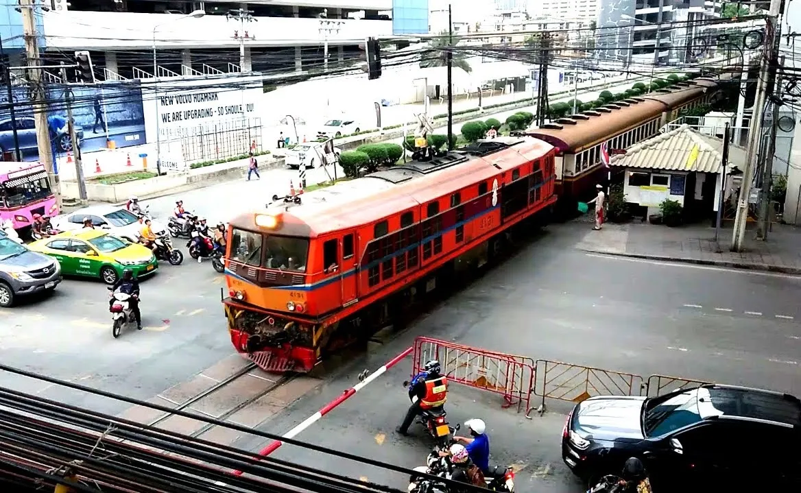 A train crossing a railroad crossing in Bangkok.
