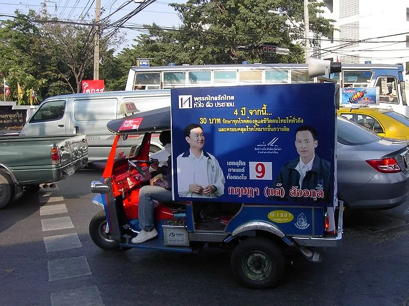 Tuk tuk carrying a poster during a Thai election campaign