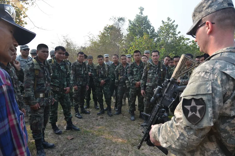 U.S. Army Staff Sgt. Andrew Renfroe, right, familiarizes Royal Thai Army counterparts with the M320 grenade launcher