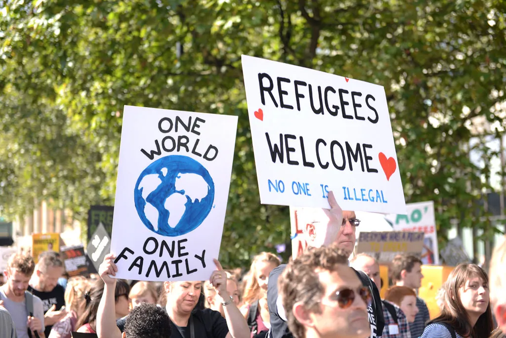 Liberals holding banners reading "One world - Refugees Welcome" during a pro-immigration demonstration in Europe