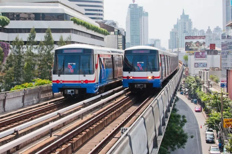 Two BTS SkyTrains pass each other at the Nana station on the Sukhumvit Line