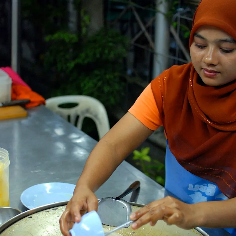 Muslim woman selling roti with banana and egg