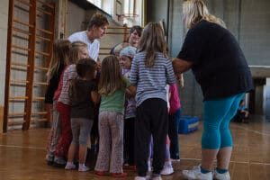 Lindweiler, Kinder bewegen sich gemeinsam im Kreis im Turnraum.