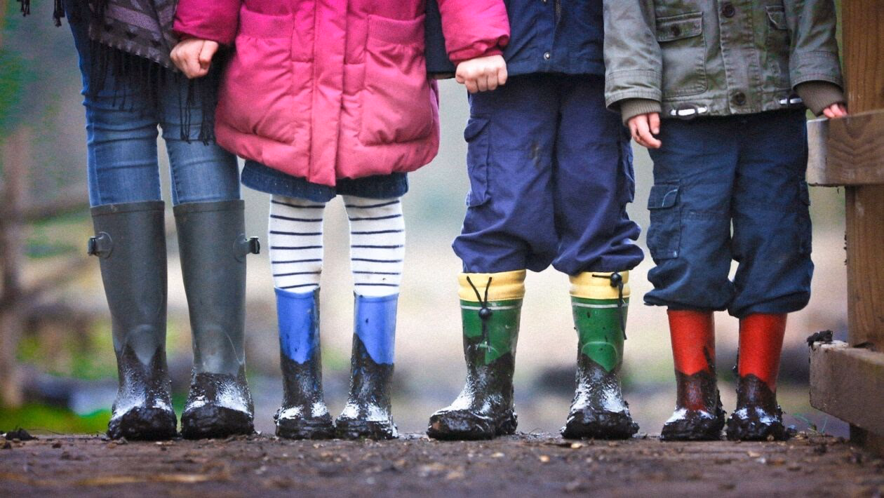 four children standing on dirt during daytime