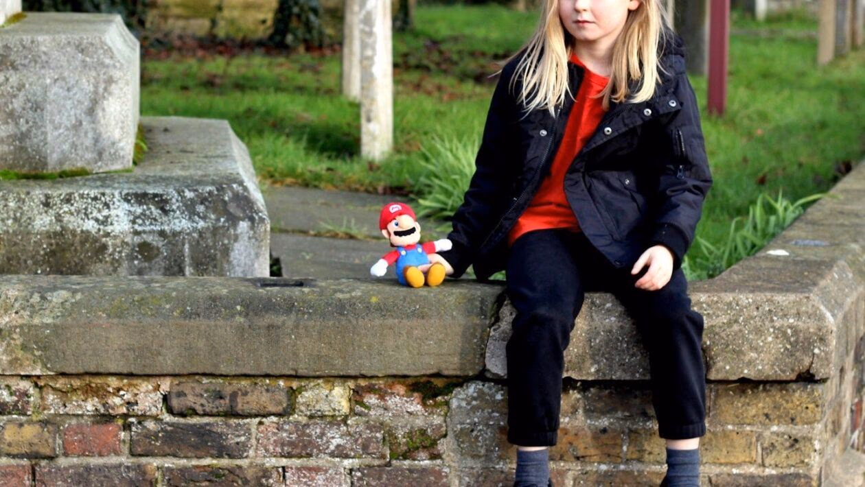 girl in black jacket sitting on concrete bench during daytime