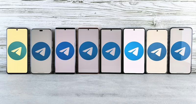 Reihe von Smartphones mit dem Telegram-Logo auf dem Bildschirm in verschiedenen Farben.