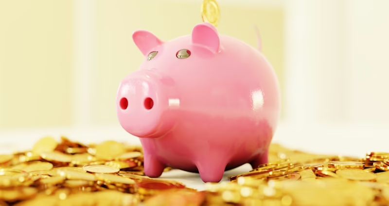 Rosa Sparschwein steht auf einem Haufen von goldenen Münzen.